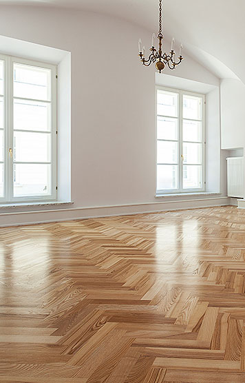 Parkett mit Fischgrätenmuster in großem hellen Raum Parkett mit Fischgrätenmuster in großem hellen Raum